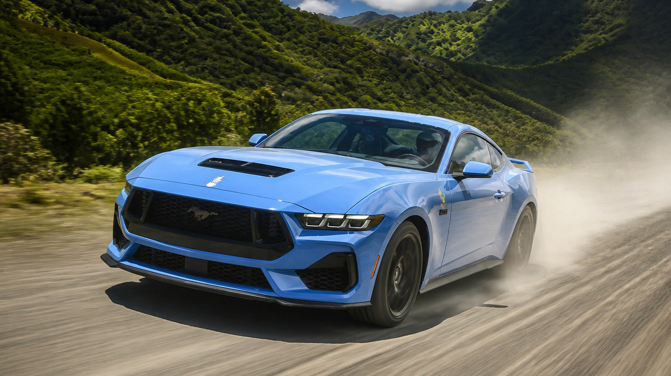 Carro desportivo azul a alta velocidade numa estrada de terra rodeada de montanhas verdes.